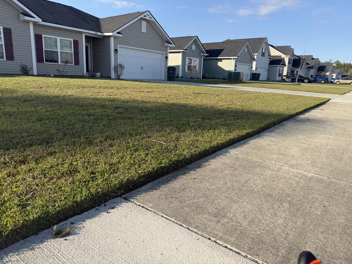 Residential lawn with clean sidewalk edging by A&P Lawn Care in Hinesville, GA
